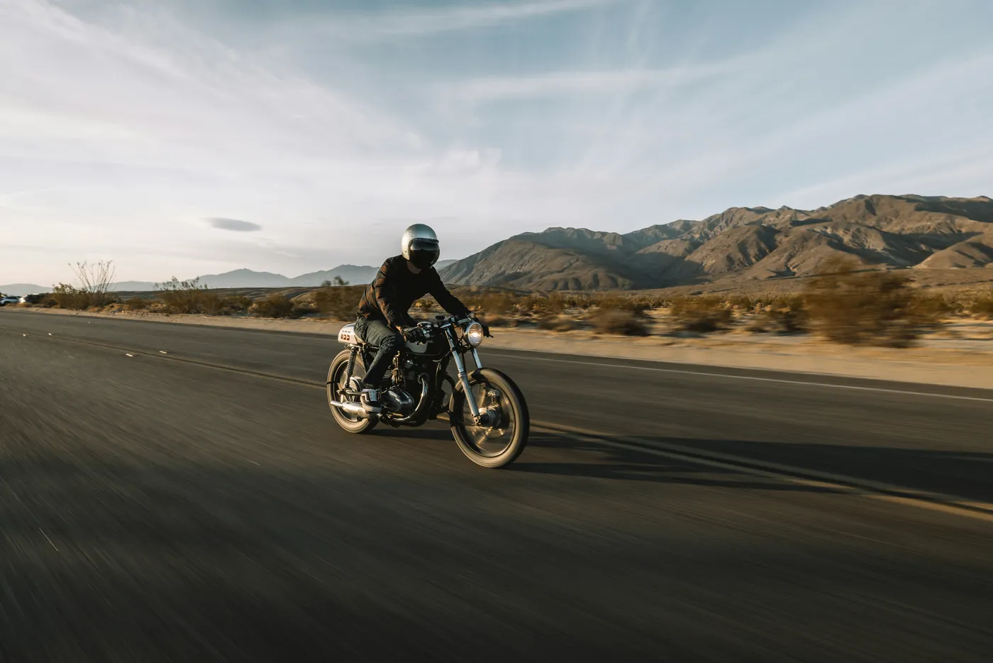 Cafe racer motorcycle on a desert road — profile cover photo