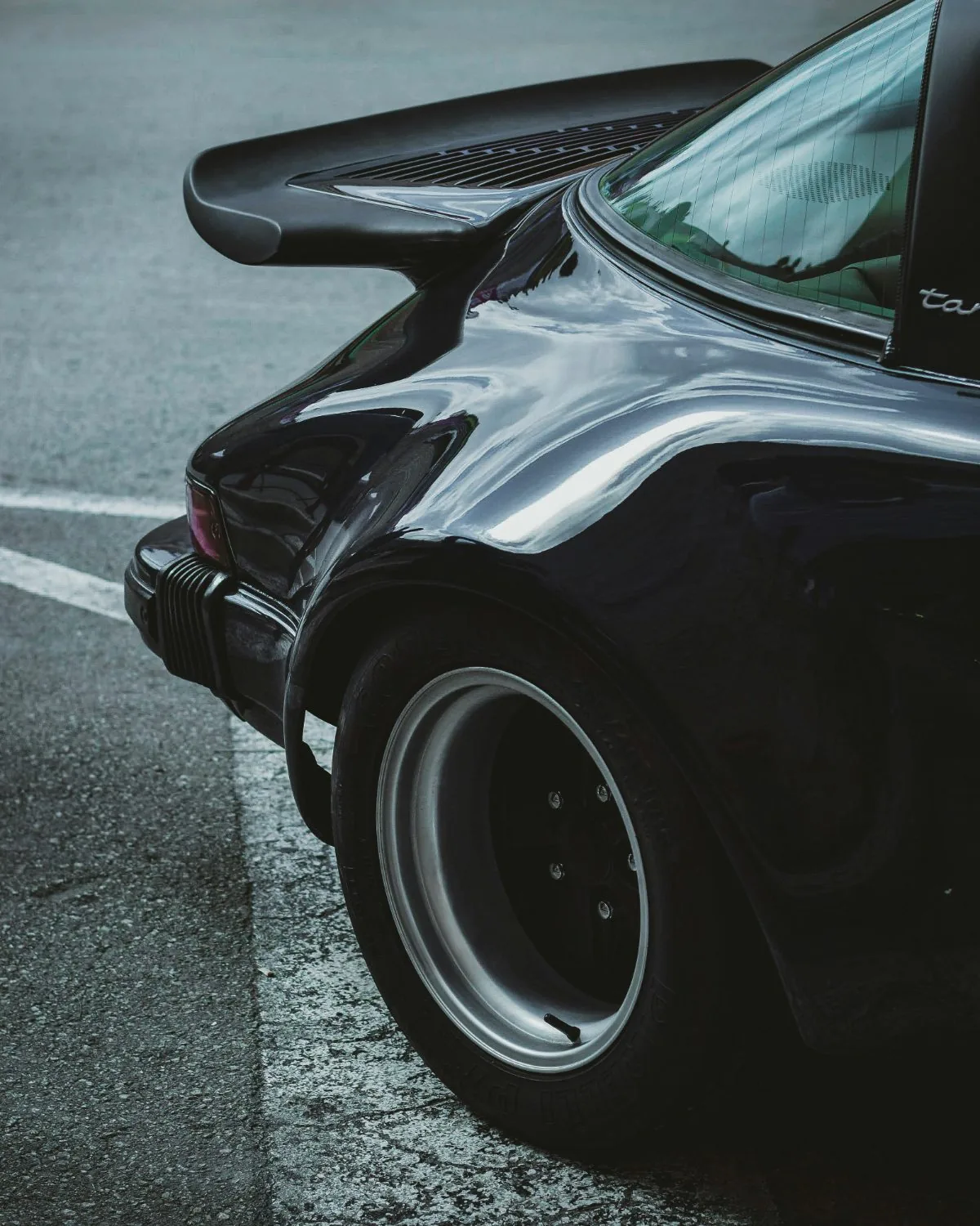 Rear fender and wheel of a black Porsche 911 Turbo