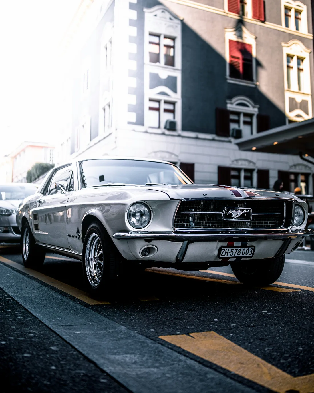 A silver 1967 Ford Mustang parked on a city street